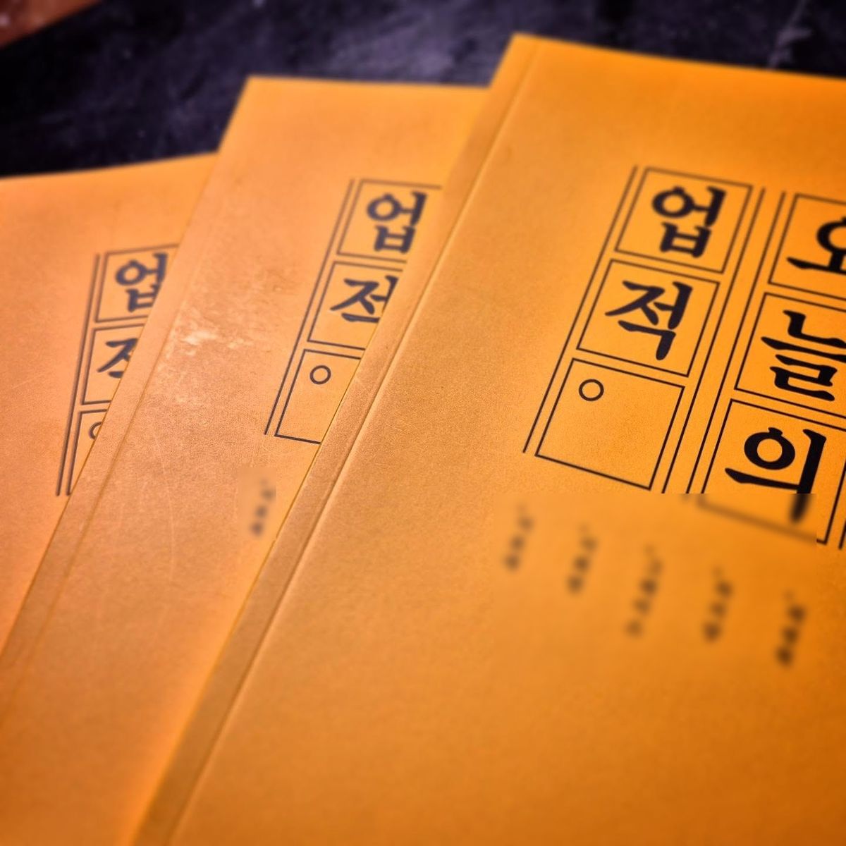 노란 표지의 〈오늘의 업적〉 여러 권