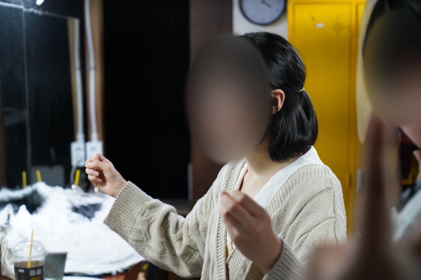 공연 전 분장실에서 단원이 준비하며 웃는 장면입니다.